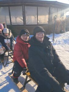 Mężczyźni i kobiety siedzące zima na sankach.